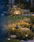 Luxent Spark solar firework burst garden light — radial starburst of warm filament strands in a backyard