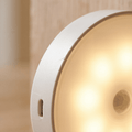 Luxent Halo motion-sensing puck light illuminating a garage workspace at night