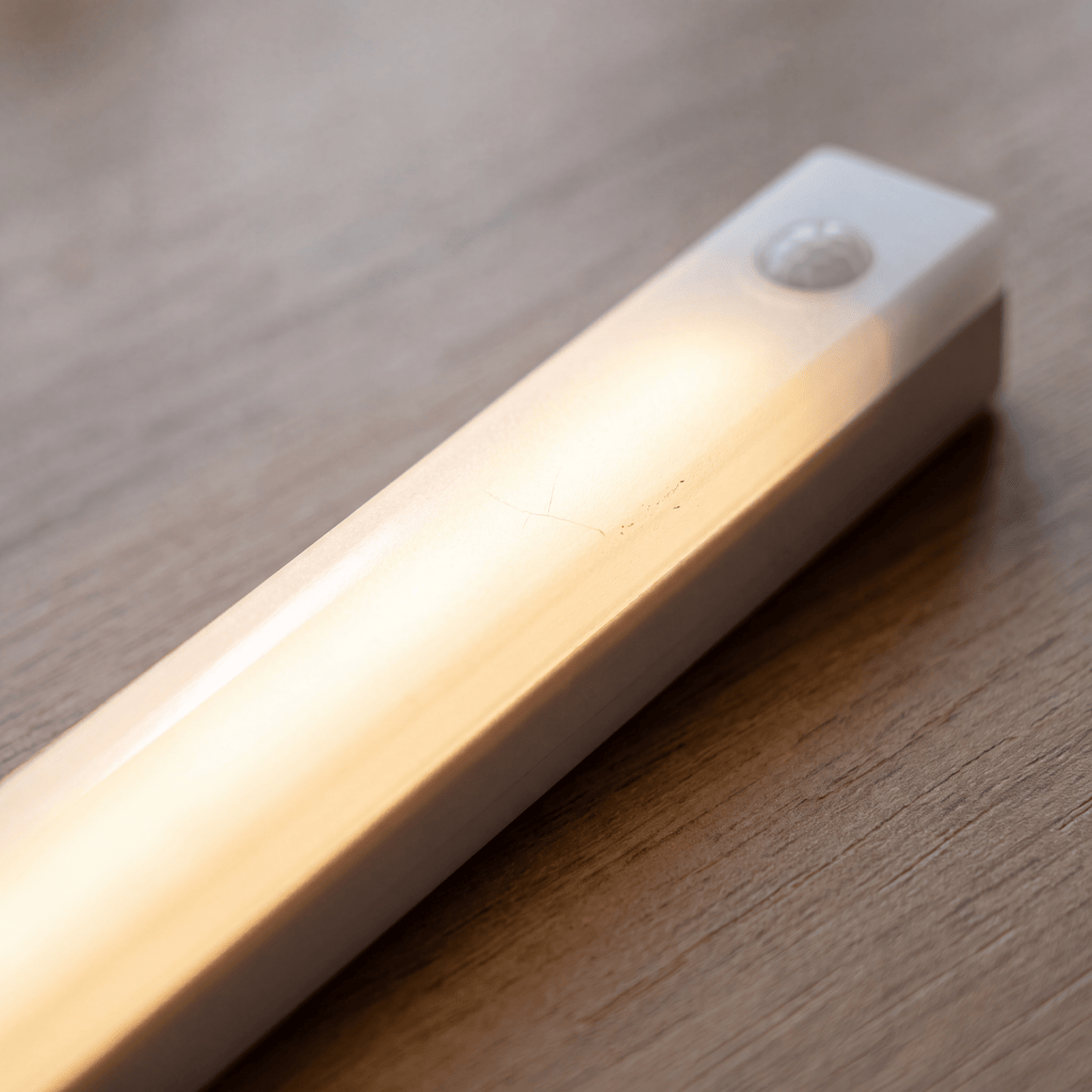 Luxent Ribbon — rechargeable motion-sensing LED light strip mounted under a deck railing at night